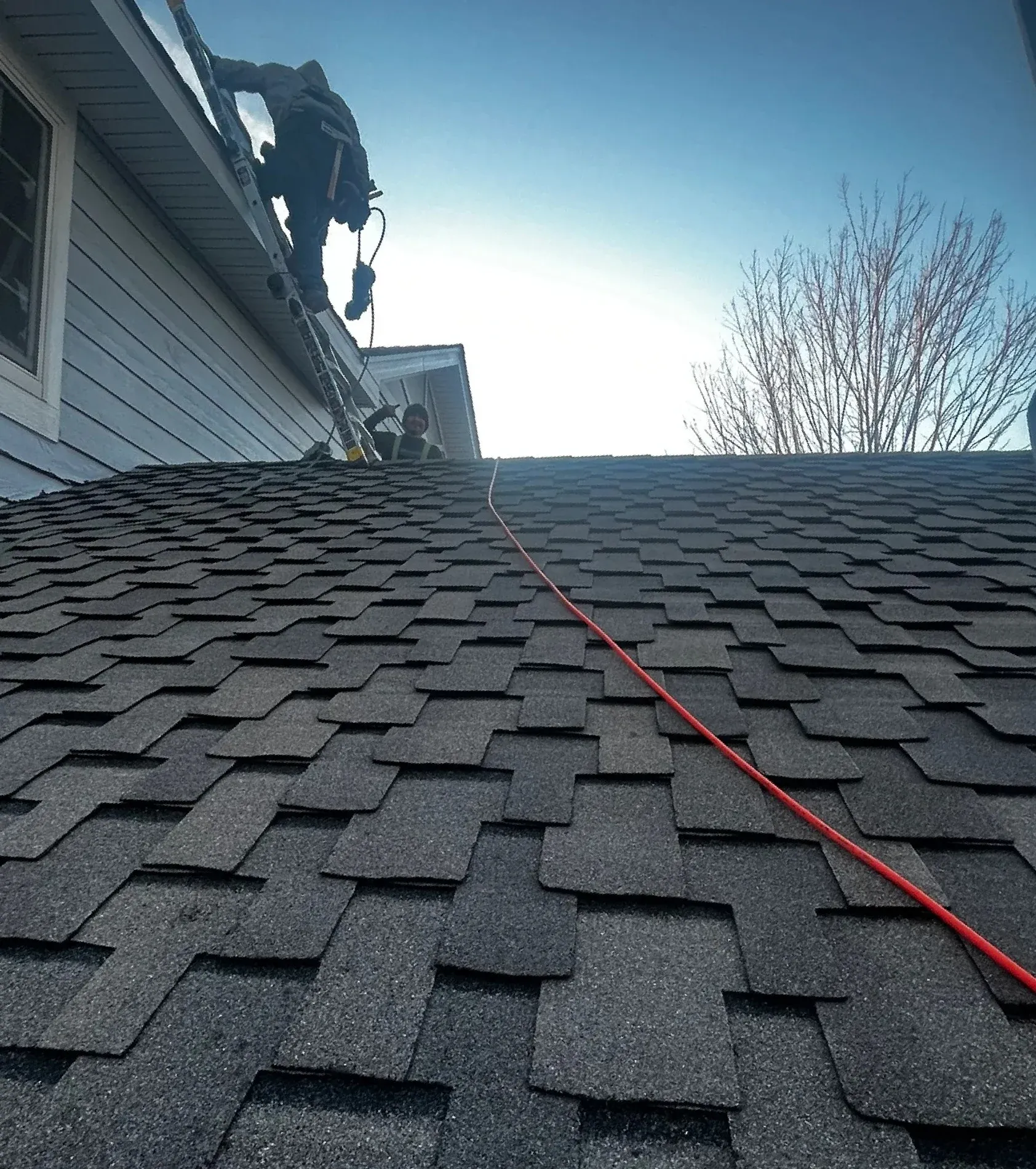 Crew member finishing shingles
