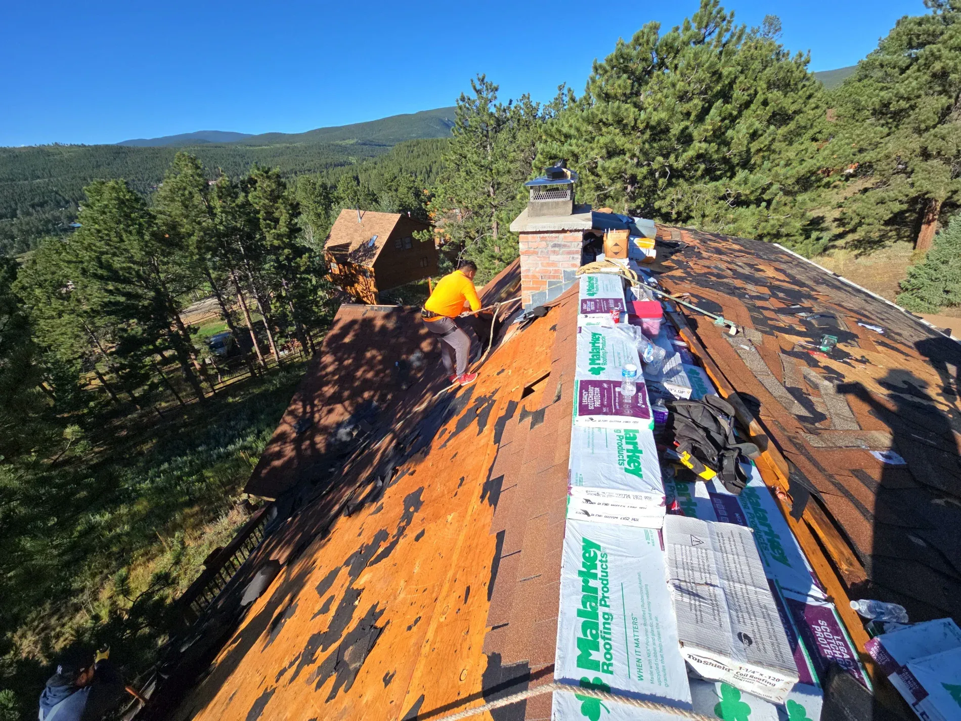 Mountain home roof replacement in progress with mountain views